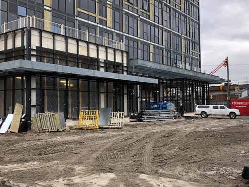 Steel entrance canopy framing and exterior wall framing at a building under construction
