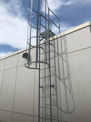 Galvanized caged access ladder with a top rest platform