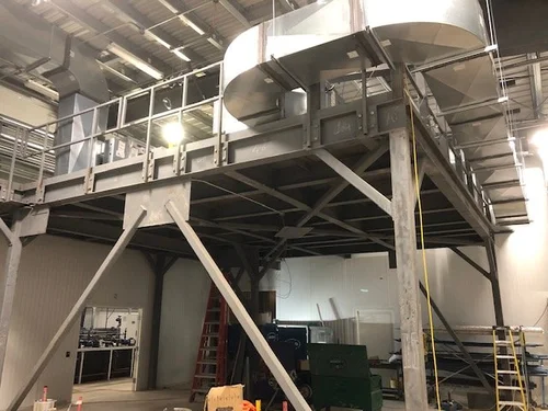 Steel equipment mezzanine with perimeter guardrails and galvanized ductwork