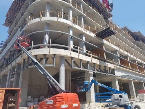 Steel outrigger brackets and curved perimeter framing supporting concrete floor slabs