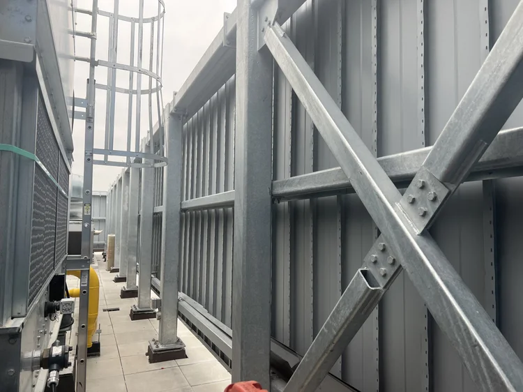 Galvanized rooftop equipment screen carried on a braced steel frame